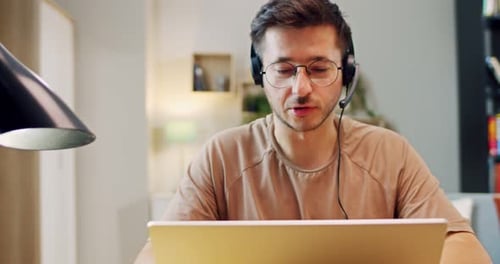 Young Adult Working on Laptop at Home Office