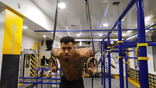 Strong African Athlete Doing Push Ups on Gymnastic Rings at Gym Muscular Afro American Sportsman