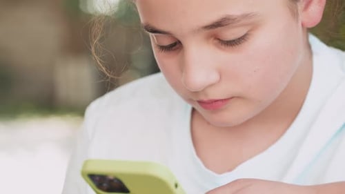 Child Focused on Phone in Close Up