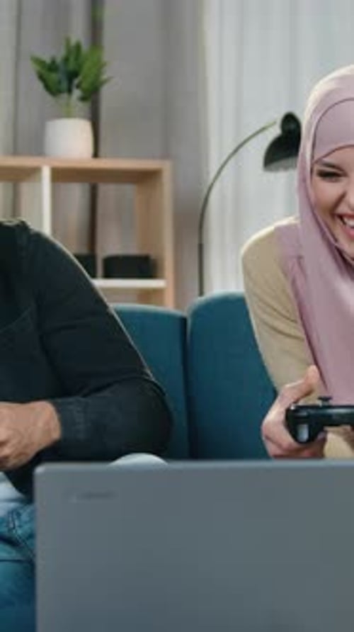 Happy Couple Laughing and Playing Video Games at Home