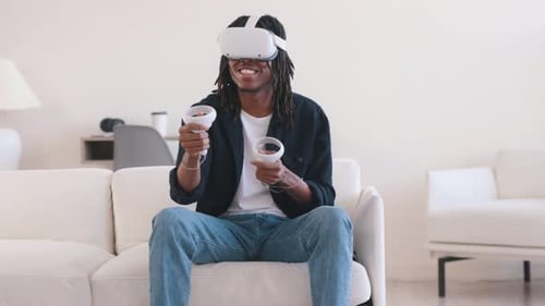 Young man playing VR game on the sofa