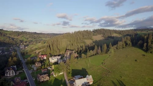 Sunset Drone View of a Mountain Village Nestled Between Hills