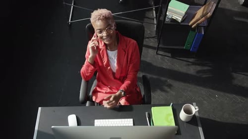 A Highly Professional Businesswoman Diligently Working at Her Desk Using a Computer