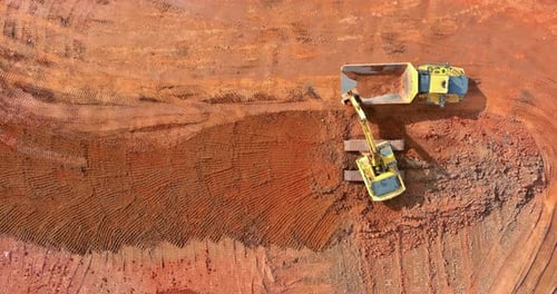 Excavator Filling Dump Truck with Dirt, Aerial View