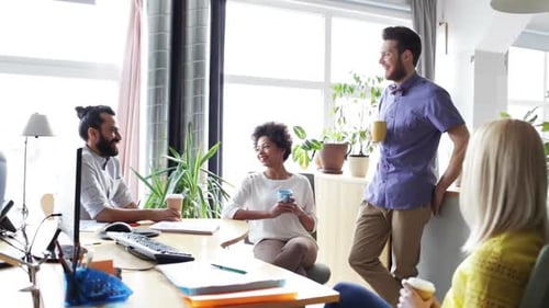 Smiling Colleagues Chatting During Coffee Break in Office