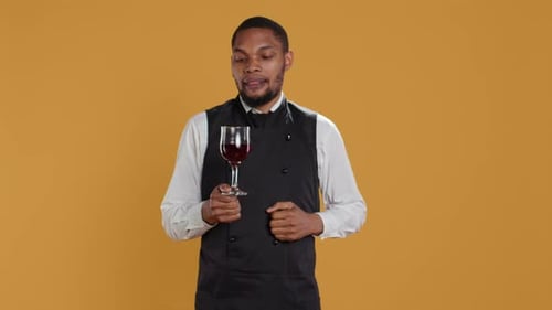 Waiter Offering a Glass of Wine to Customers Waiting for Food at the Table