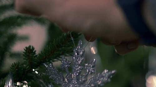 Hand hanging Christmas tree decoration, close up