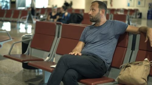Impatient man awaits delayed flight at international airport terminal