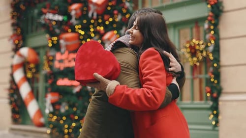 Happy Couple Hugging with Christmas Gift