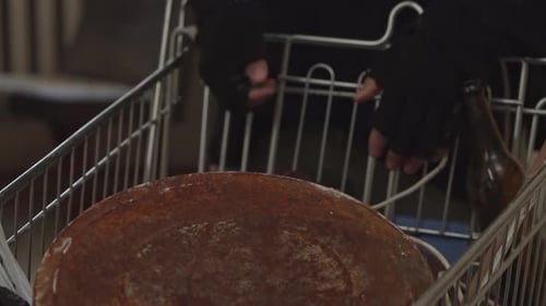 Unrecognizable Homeless Man Standing is the Room of an Abandoned Building Searching for Useful
