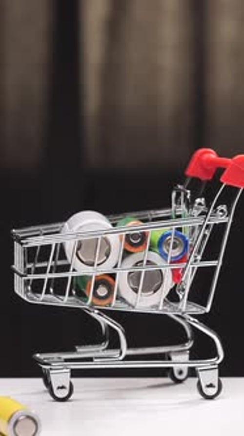 Hand Loading Batteries Into Miniature Shopping Cart