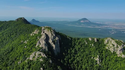 An Aerial View of a Mountain Range Adorned with Trees and Rocks