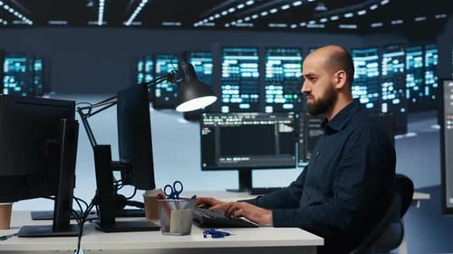 Man Programming in High Tech Facility with Server Rows
