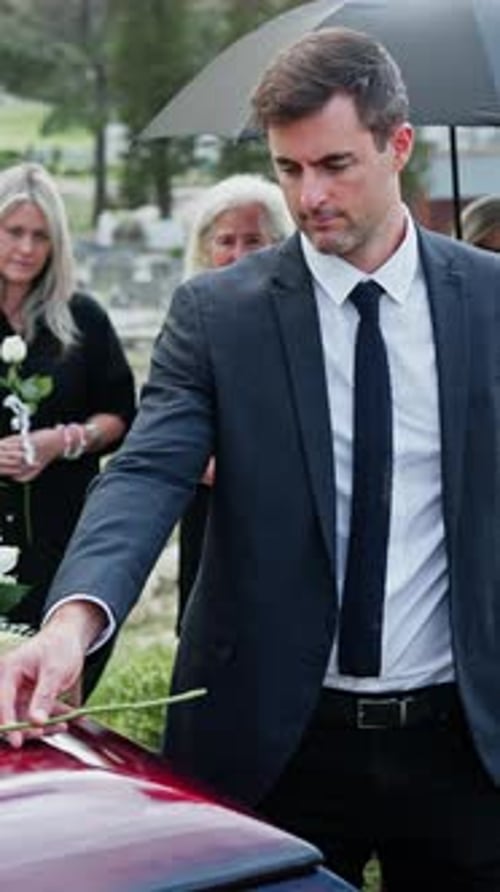 Sad, man or white rose on coffin at funeral for grief, mourning death or final goodbye in cemetery