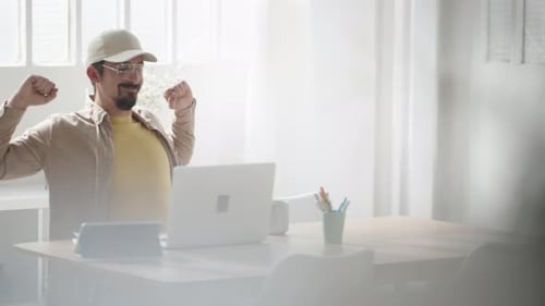 Man Working at Laptop Computer in Bright Office