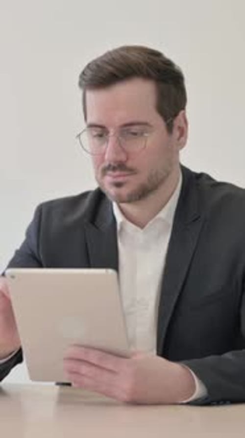 Man in Suit Using Tablet Device Indoors