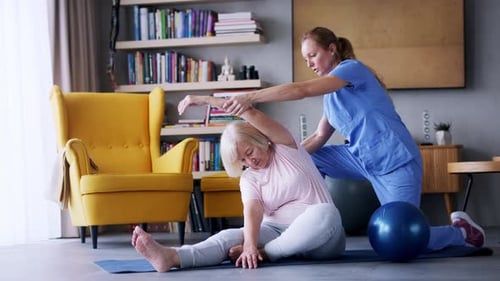 Senior Woman Stretching with Assistance from Adult