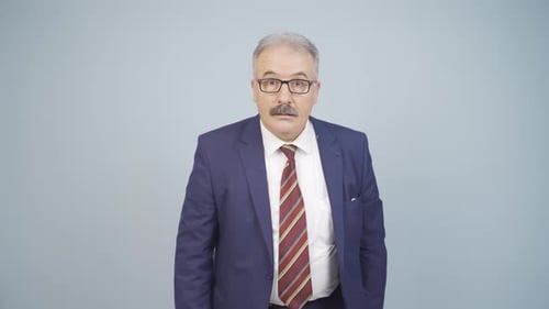 Man in Suit Gestures and Crosses Arms