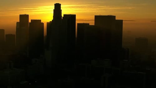 Los Angeles skyscrapers silhouetted against a vibrant sunrise aerial view