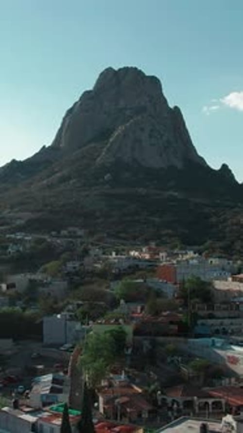 Aerial flyover Bernal pueblo magico overseeing the iconic Peña de Bernal monolith, one of the