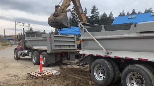 Construction Zone: Excavator Loading Dump Truck with Soil in British Columbia, Canada