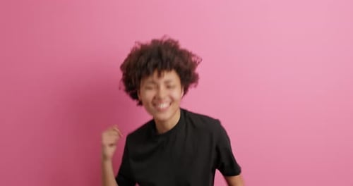 Excited Woman Dancing Against Pink Background