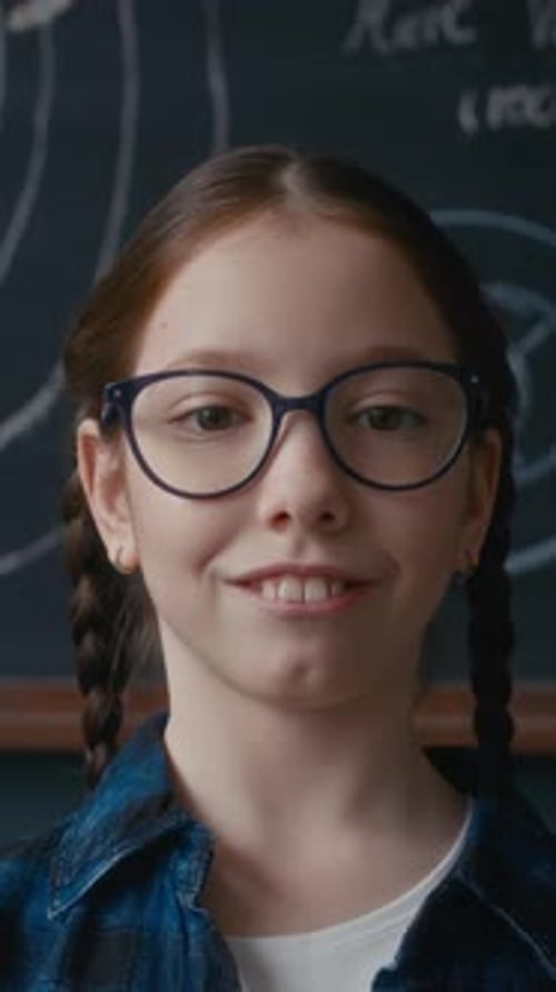 Vertical Portrait of Student Smiling in Front of Solar System Chalkboard