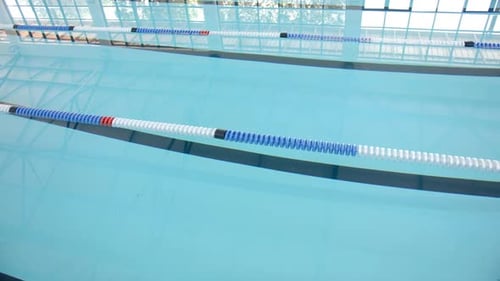 Leeres Schwimmbad mit Spurtrennwänden, bereit für Wettkämpfe im Schwimmsport, Kopierraum