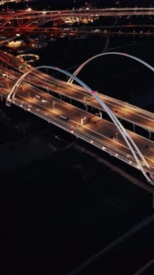 Aerial view of a lit-up highway interchange in Dallas at night