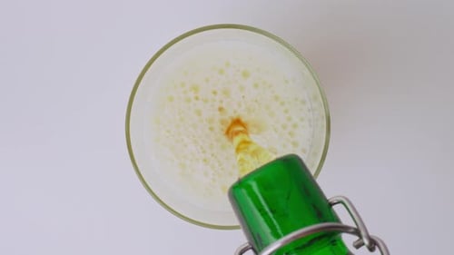 Pouring fresh foamy beer into a glass overhead
