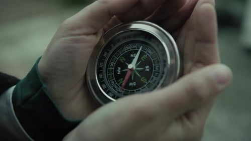 Hands Hold Compass Finding Direction in Urban Setting