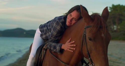Portrait of a Beautiful Woman Riding a Horse by on Seaside Beach at Sunset. Professional F