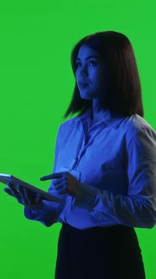Female Data Center Technician Working on Tablet on Green Background