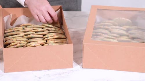 Packing SprinkleAdorned Sugar Cookies Into Boxes