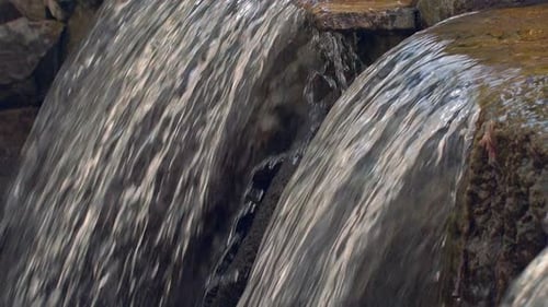 Streams of Water Flowing From River Cascade. Closeup of Water Falling From