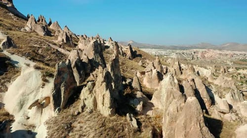 Flying over jagged rocky landscape of Goreme, unique Cappadocia formations in Turkey