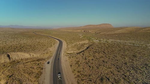 Aerial View of Winding Desert Highway Through Vast Mountain Landscape