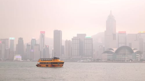 Hong Kong city ferry transport through river. Skyscrapers in background