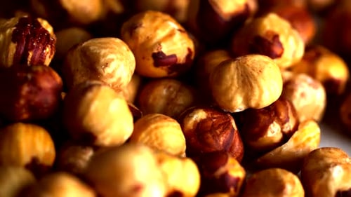 rotating close-up of roasted hazelnuts showcasing their natural texture and golden brown tones. The