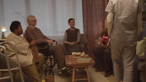 Caregiver Joining Nursing Home Residents Sharing Calm Evening in Cozy Lounge
