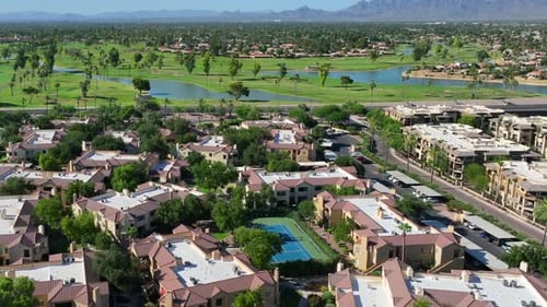 Southwest USA aerial view: lush golf courses, water features, and terracotta-roofed residences, with