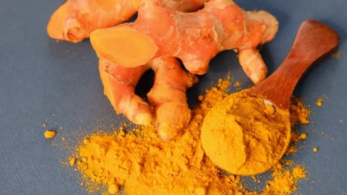 Turmeric Powder and Roots Curcuma Longa Kurkuma Panning Turmeric on Black Background Top View Close