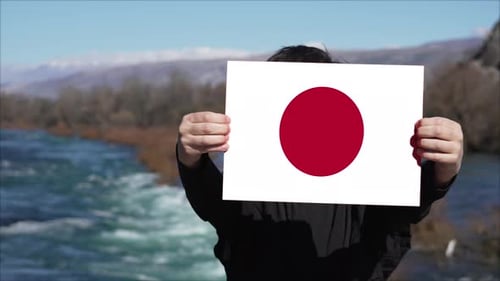 Person, die ein Banner mit der Flagge Japans hält