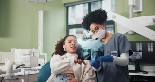 Dentist Showing X-Ray to Young Adult Patient