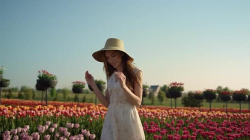 Lady Walking In Tulip Garden At Summertime. Gentle Woman In Dress Spending Time At Flowers Field....