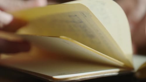 Pages being flipped in a journal on a table