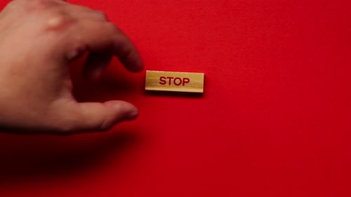 um fundo vermelho quente sem sombras, o homem colocou cubos de madeira à mão com palavras coloridas dispostas