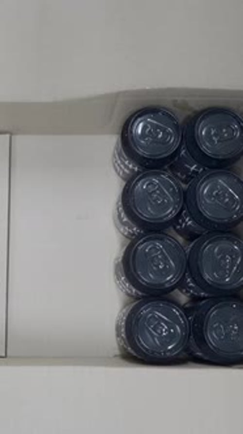 Top View Of Tattoed Worker Packing Canned Beers In A Box In A Beer Factory Overhead Shot