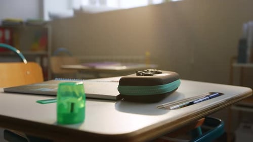 Reducir el material escolar sobre una mesa de madera en el auditorio de