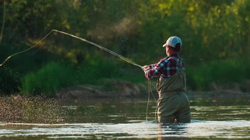 Fly fishing. Man fly fishing on the wild river with lots of insects flying in the air